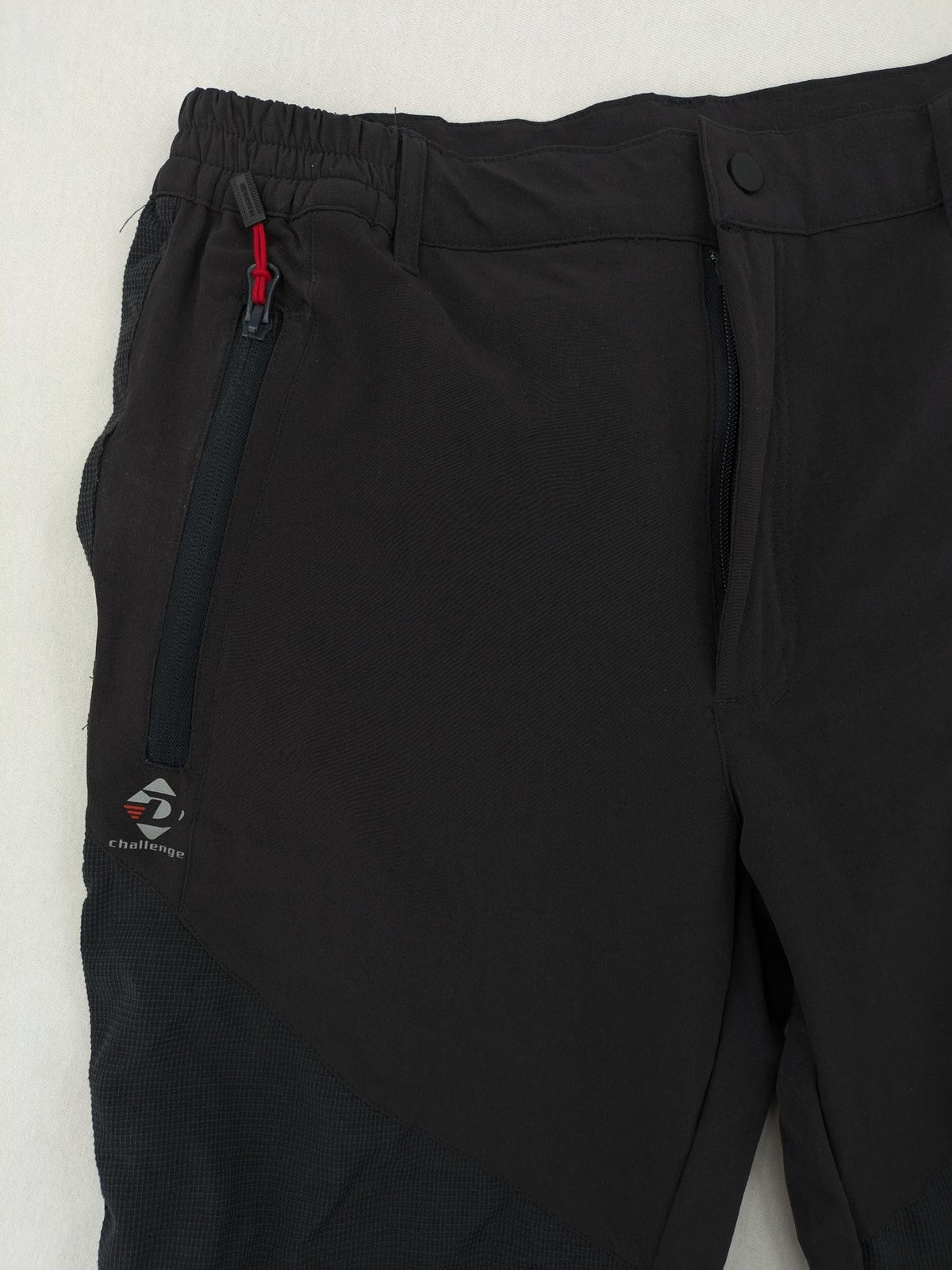 Outdoor black capri pants with elastic waistband and multiple zippered pockets.