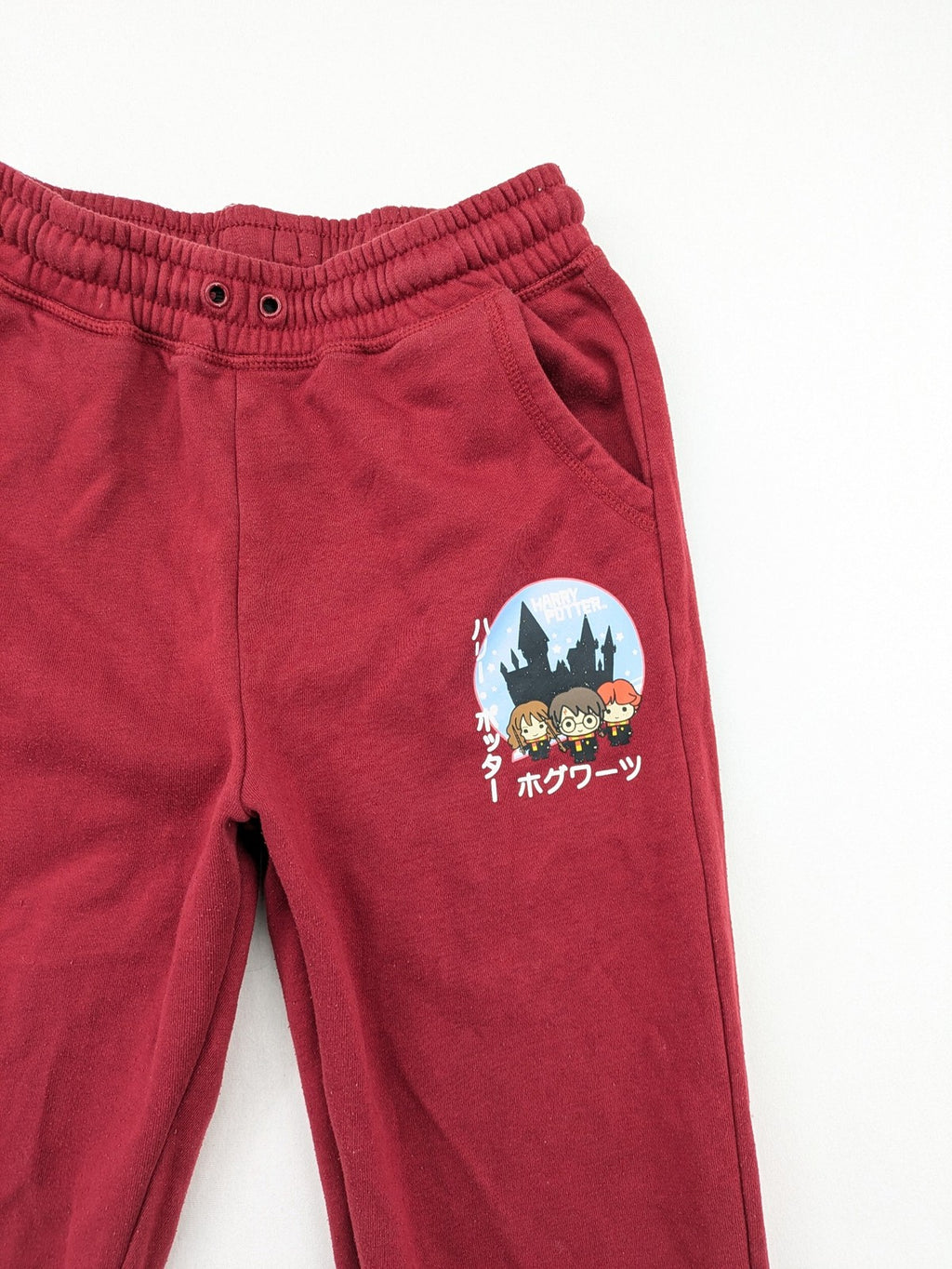 Harry Potter burgundy sweatpants featuring "HOGWARTS" print and Chibi graphic of Harry, Ron, Hermione.