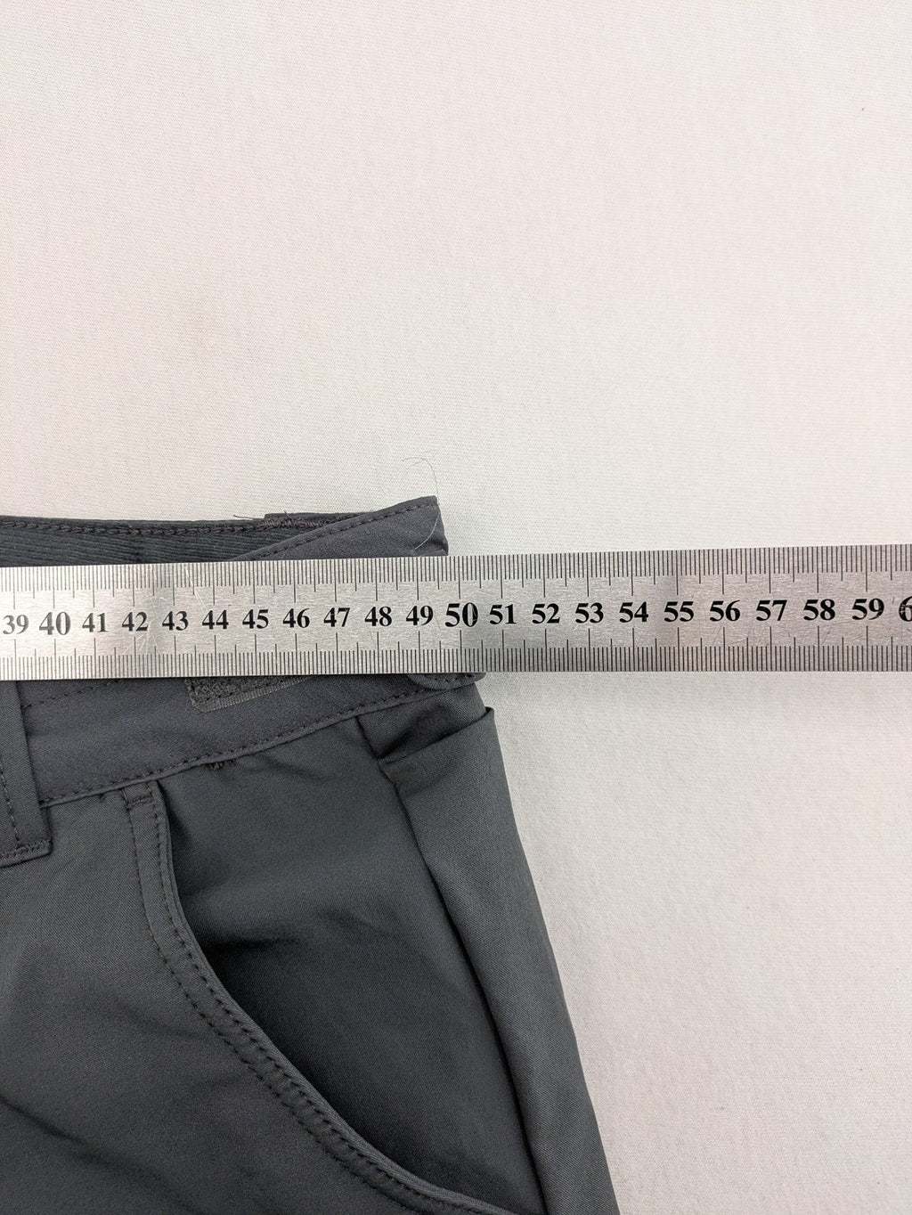 Outdoor grey functional shorts with adjustable velcro waistband and zippered leg pocket.