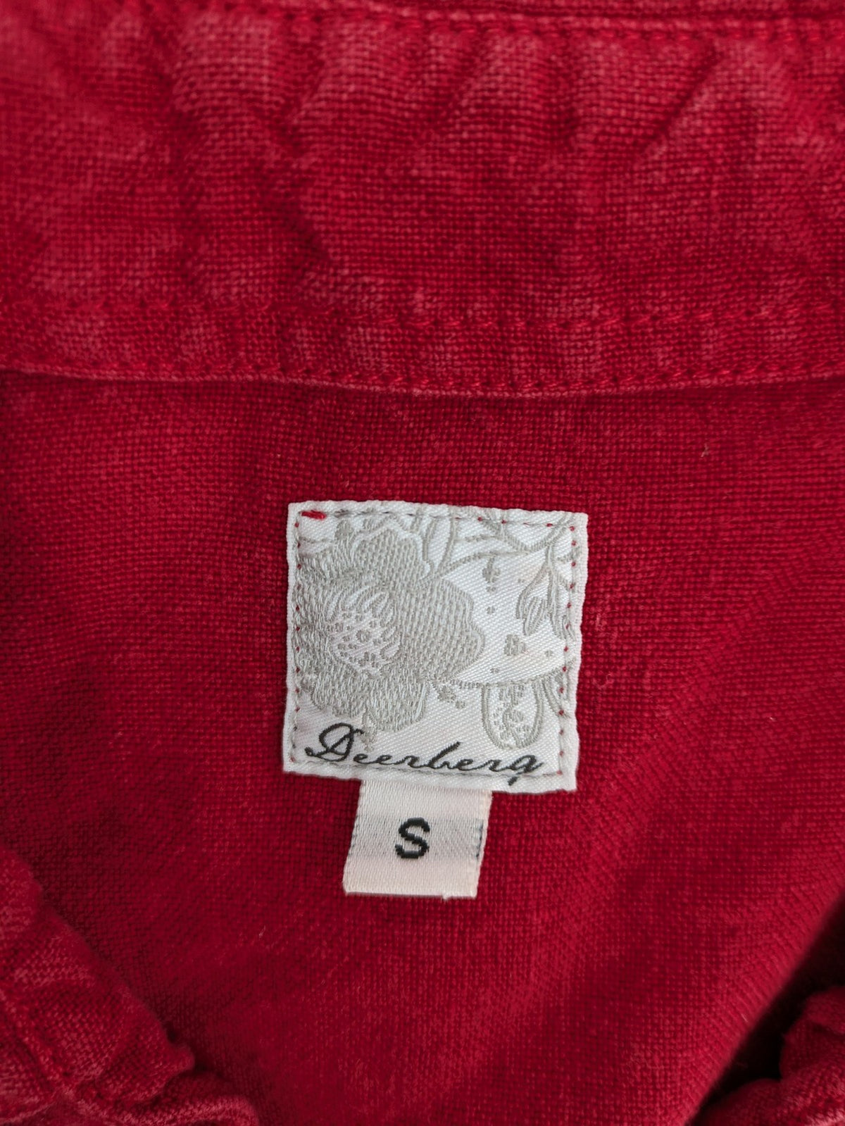 Deerberg red short-sleeve linen blouse with collar, button placket, and side slits.