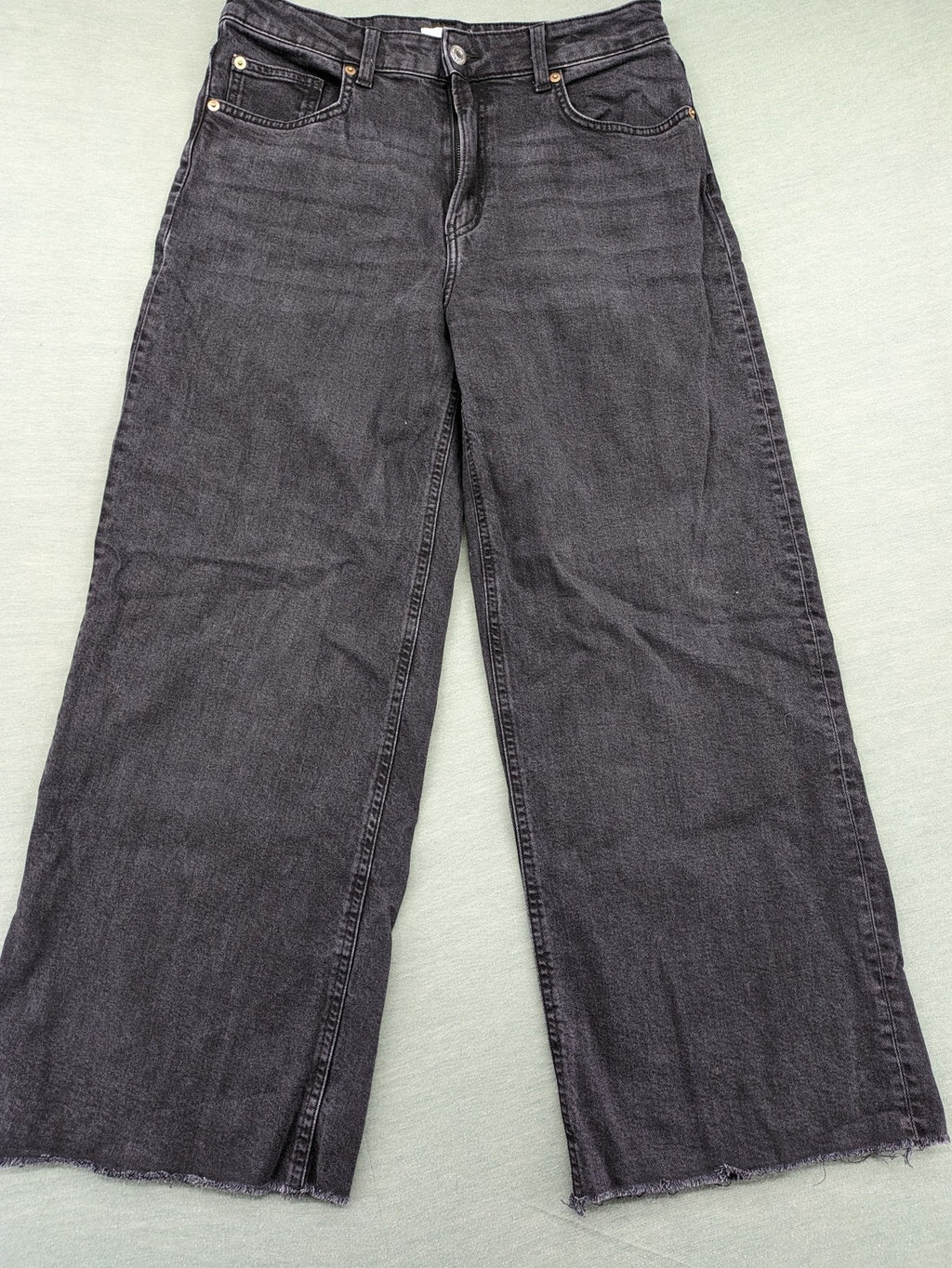 H&M black grey wide leg cropped jeans with frayed hem and high waist design.