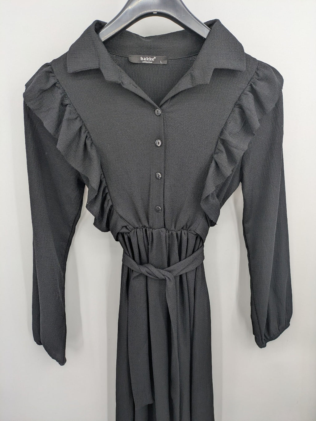Hakke black maxi dress with ruffle details, long sleeves, and matching belt.