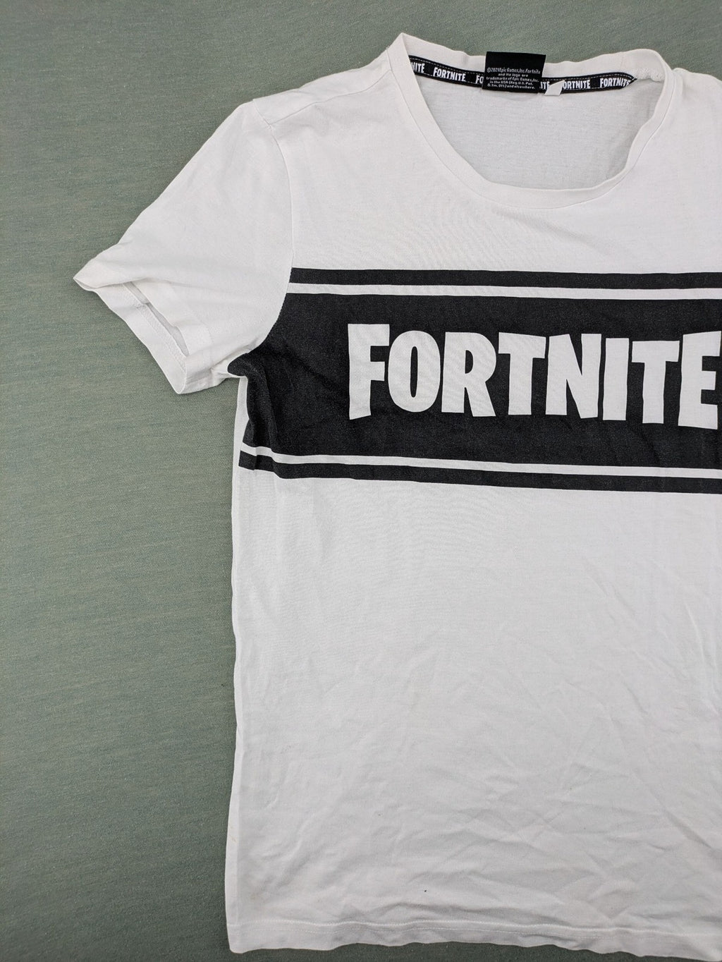 Fortnite white t-shirt with black chest stripe and Epic Games logo, 100% cotton.