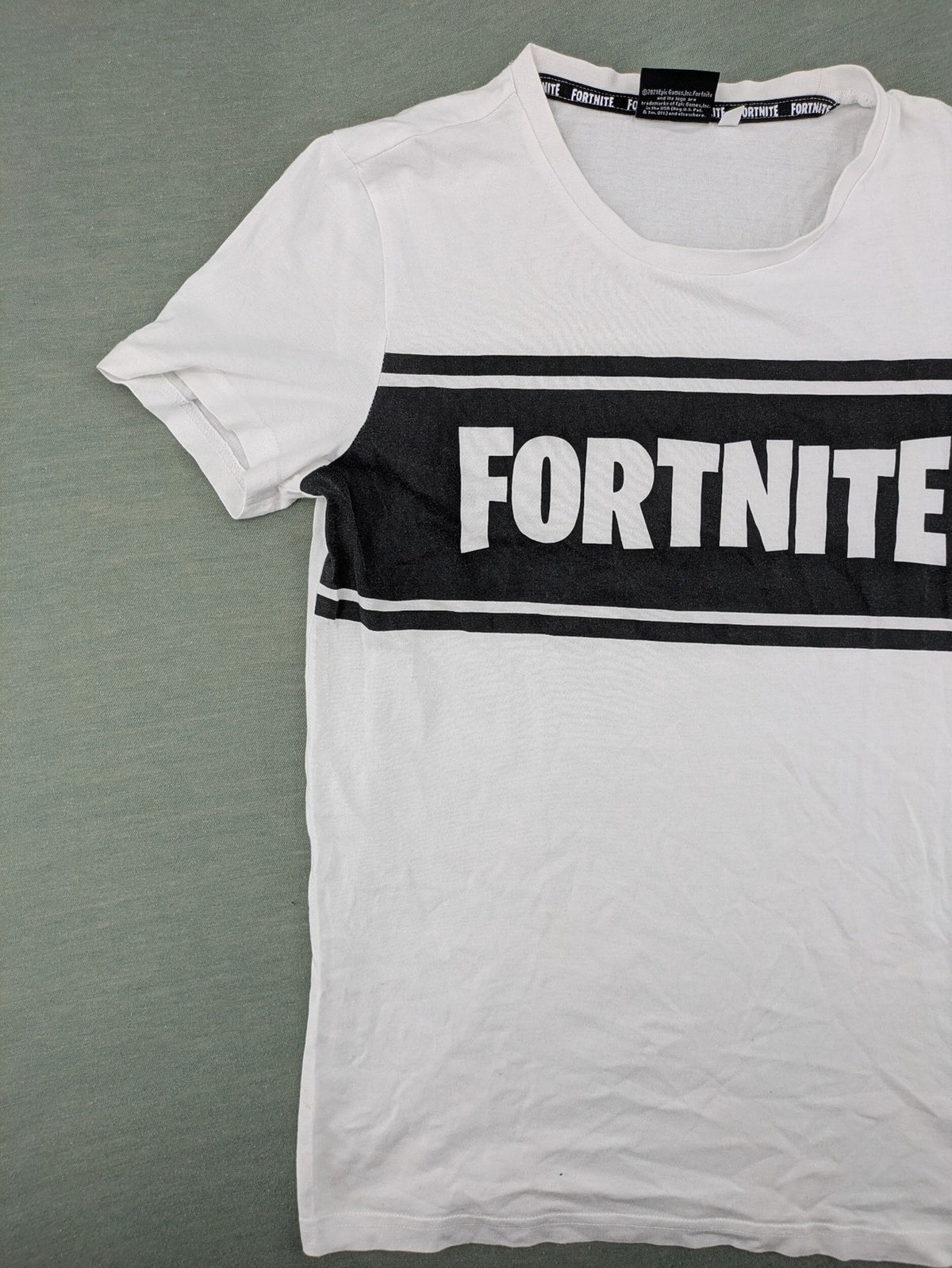 Fortnite white t-shirt with black chest stripe and Epic Games logo, 100% cotton.