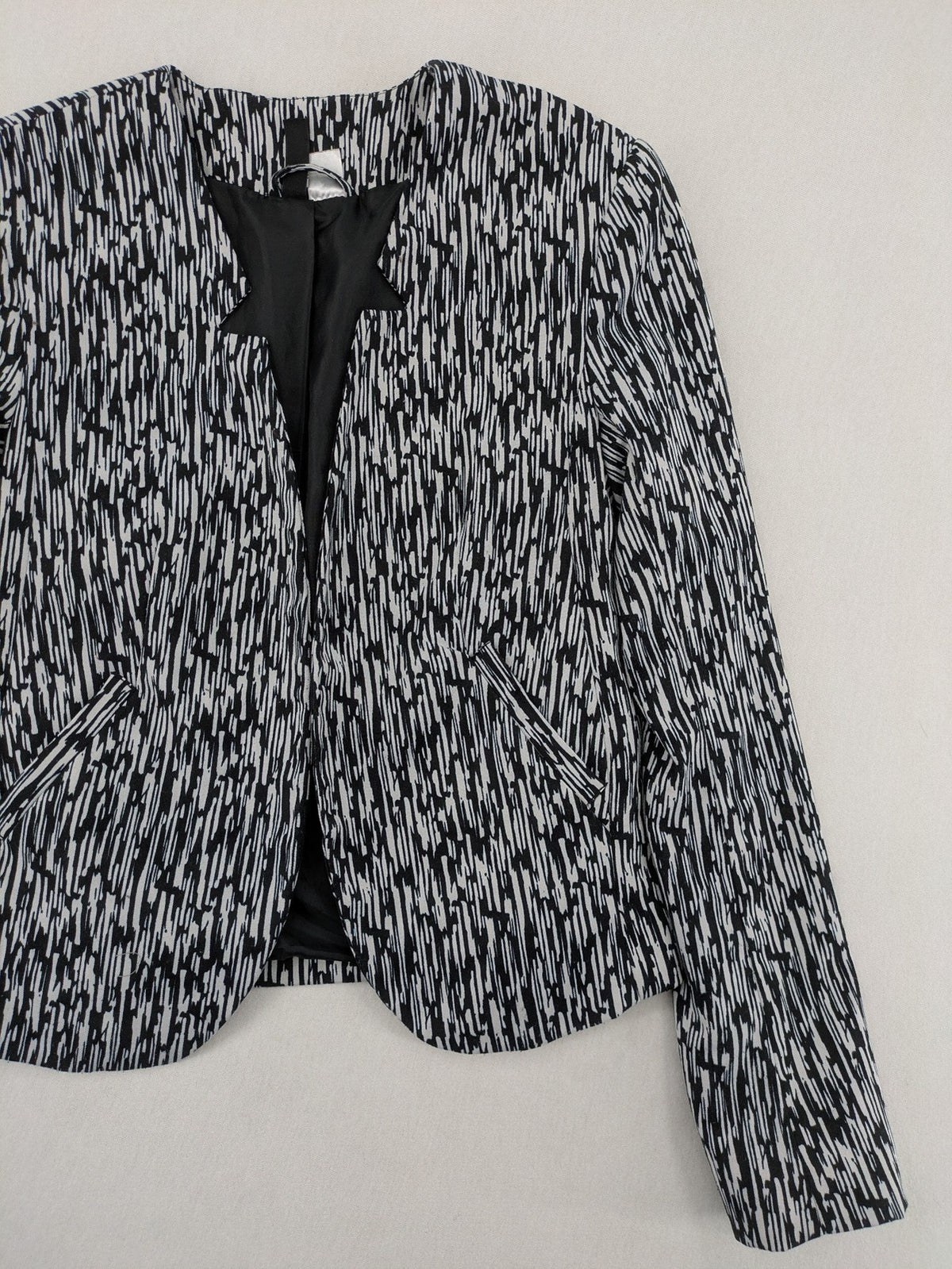 H&M Divided black and white patterned blazer with open front and two front pockets.