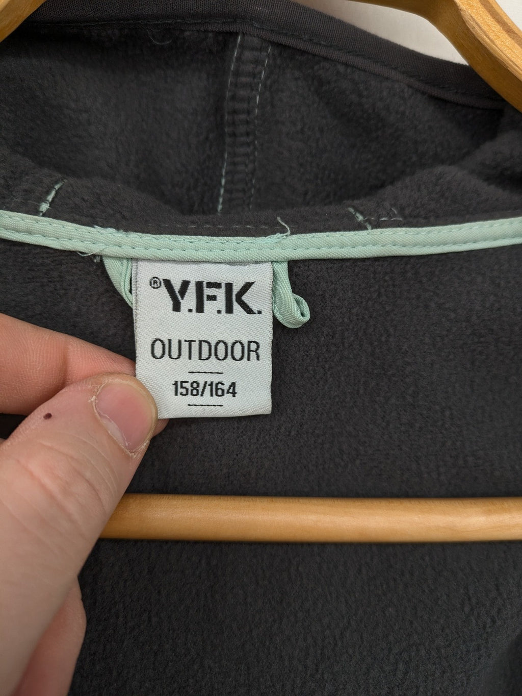 YFK outdoor jacket mint green softshell with dark grey fleece lining and hood.