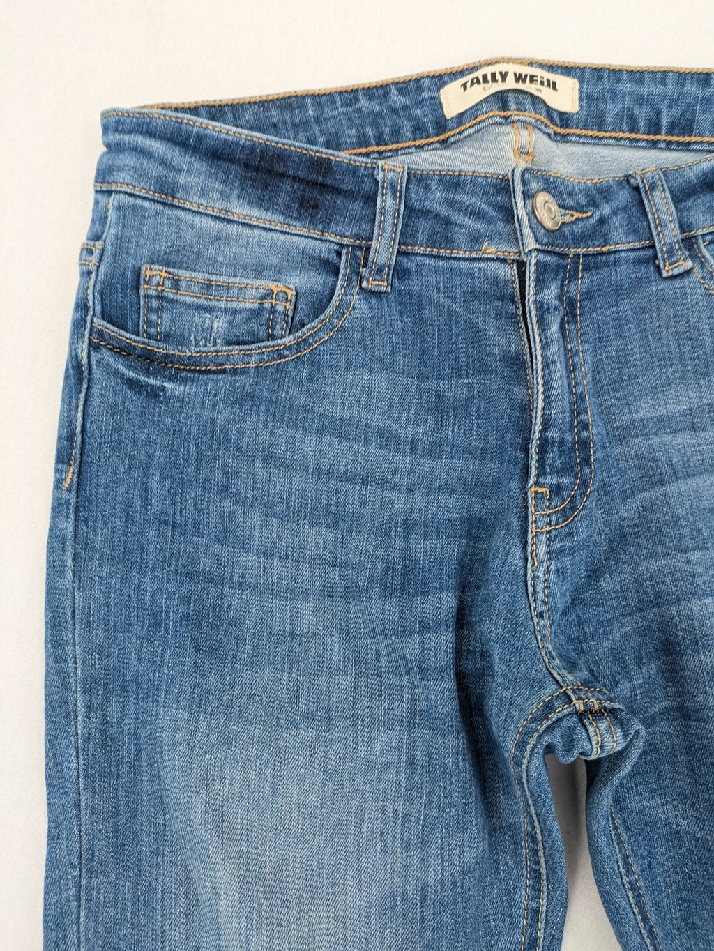 Tally Weijl blue bootcut jeans with distressed knees and raw hem detail.