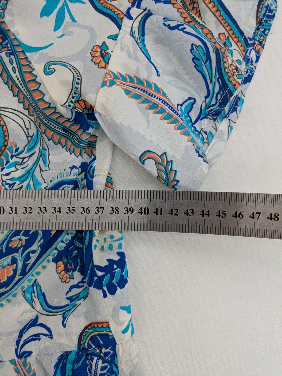 Atmosphere orange summer dress with colorful paisley pattern and cold shoulder design.