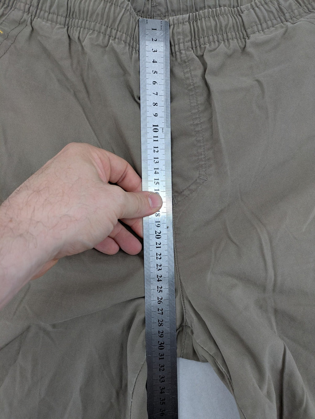 Nike khaki training pants with logo, elastic waistband, and practical pockets.