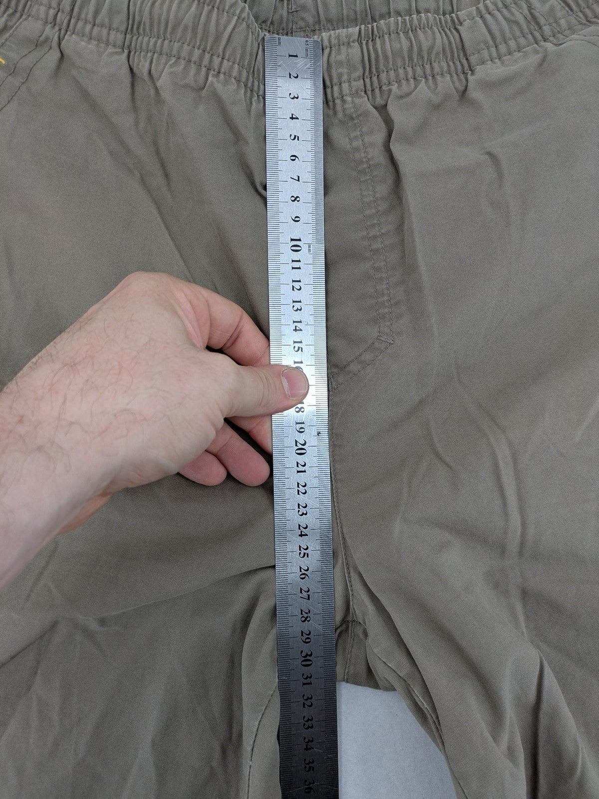 Nike khaki training pants with logo, elastic waistband, and practical pockets.