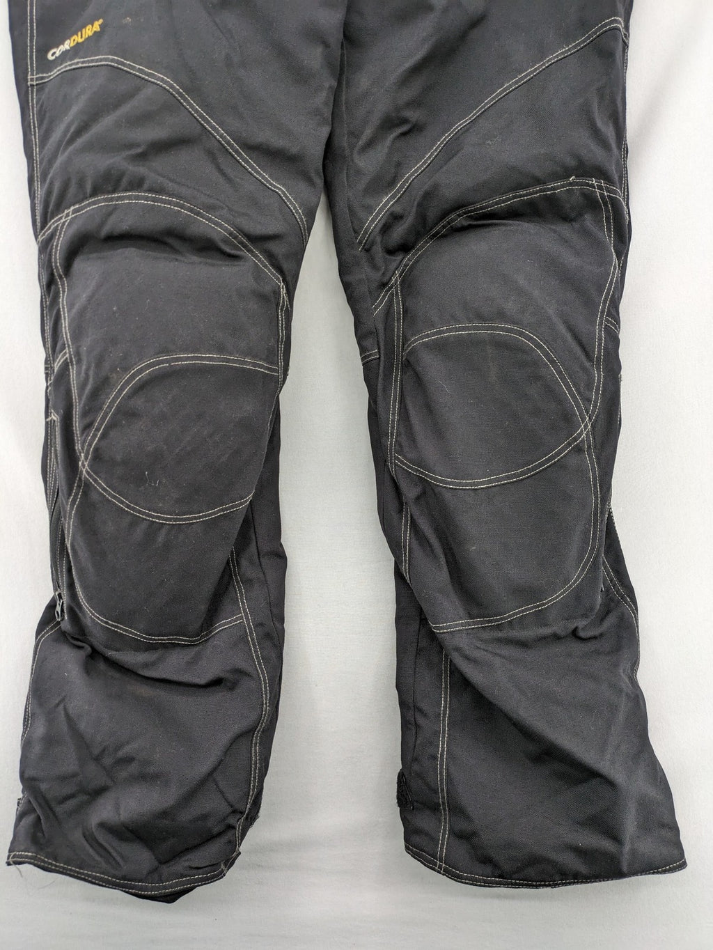 Rukka black motorcycle chaps with grey accents and CE knee protectors, made from durable Cordura.
