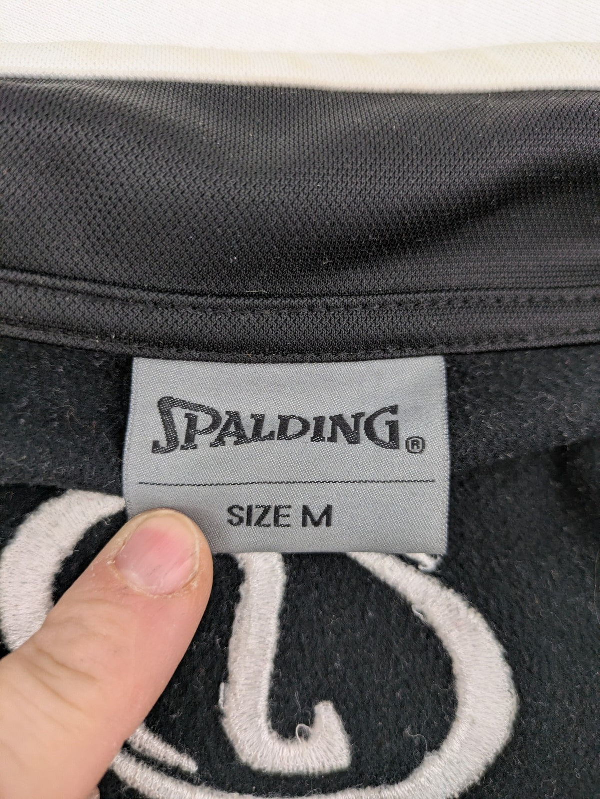 Spalding black training jacket with orange and white accents, Rasta Vechta logo, zip front.