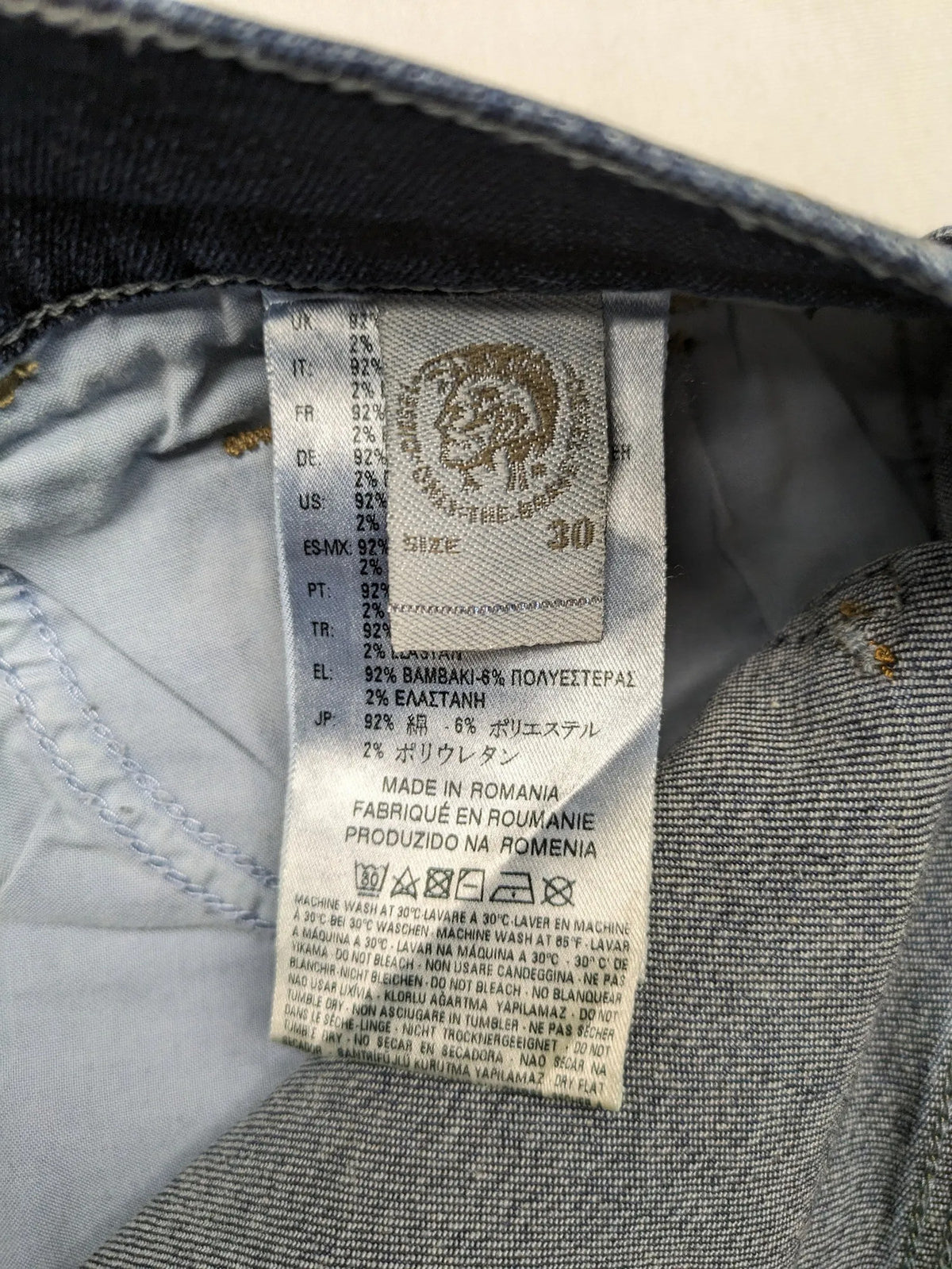 Diesel blue straight jeans with regular waist, dark wash, and stretch material.