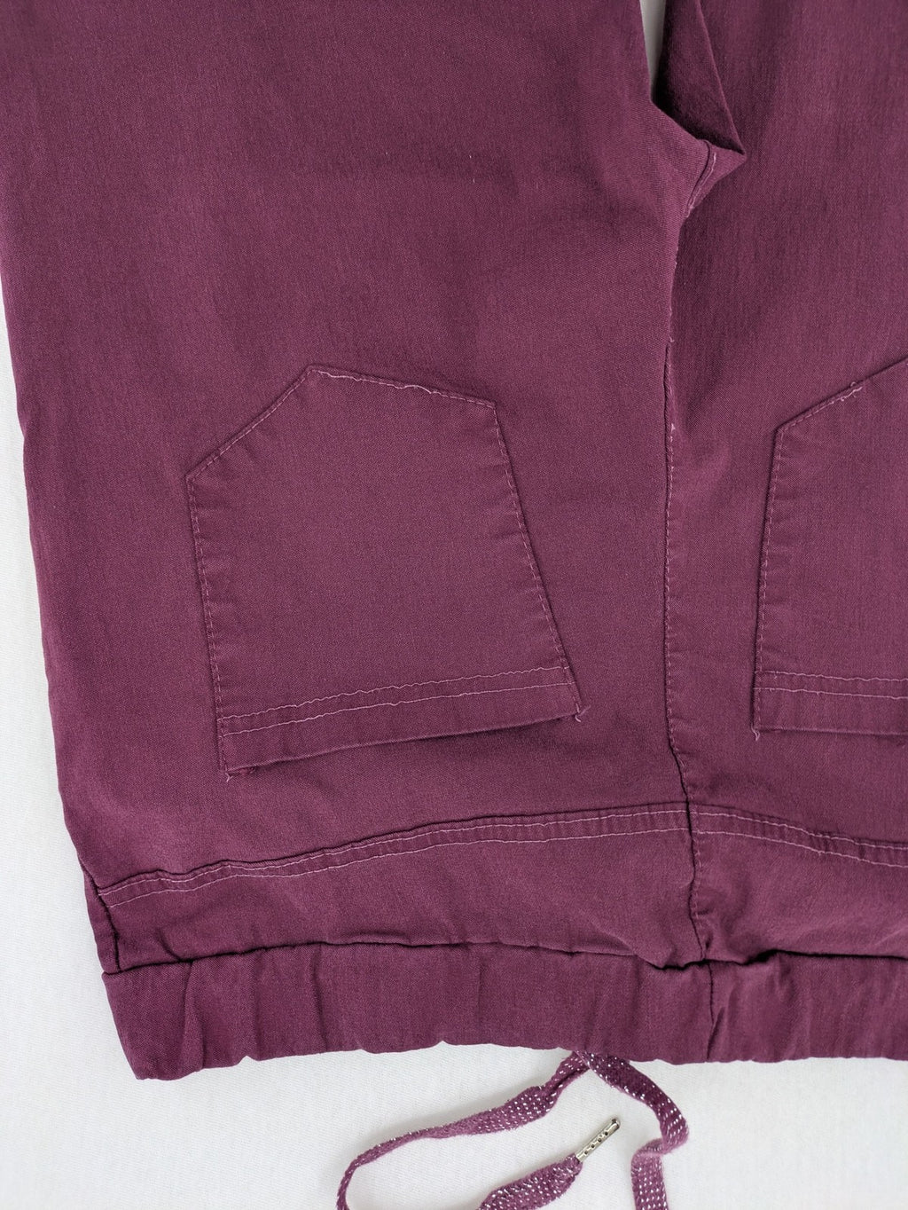 Pink Cherry pants pink stretchy fabric with decorative buttons and elastic waistband.