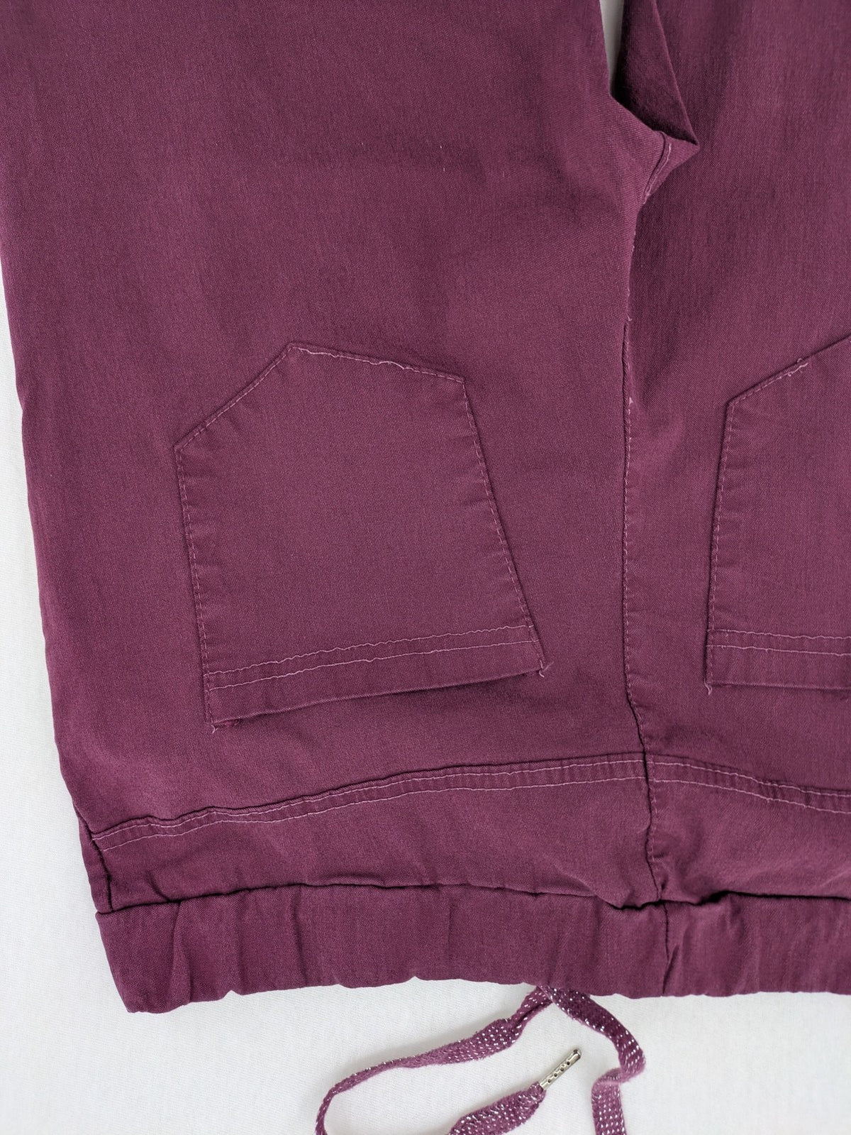 Pink Cherry pants pink stretchy fabric with decorative buttons and elastic waistband.
