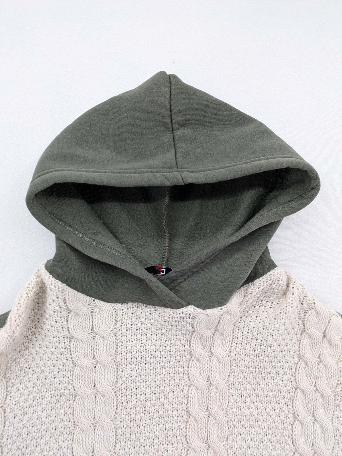 DCJ cream and olive green hoodie with cable knit pattern and graphic text sleeves.