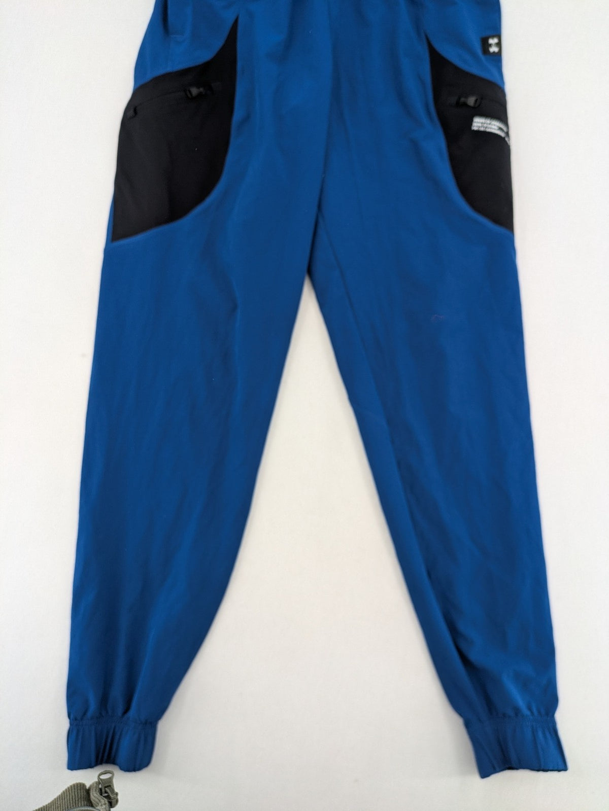 Under Armour blue HeatGear joggers with black accents and zippered cargo pockets.