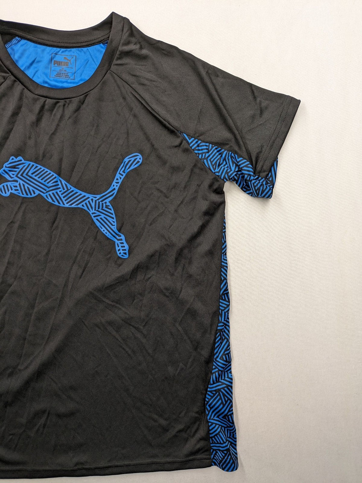 Puma black performance T-shirt with blue geometric side panels and iconic logo.