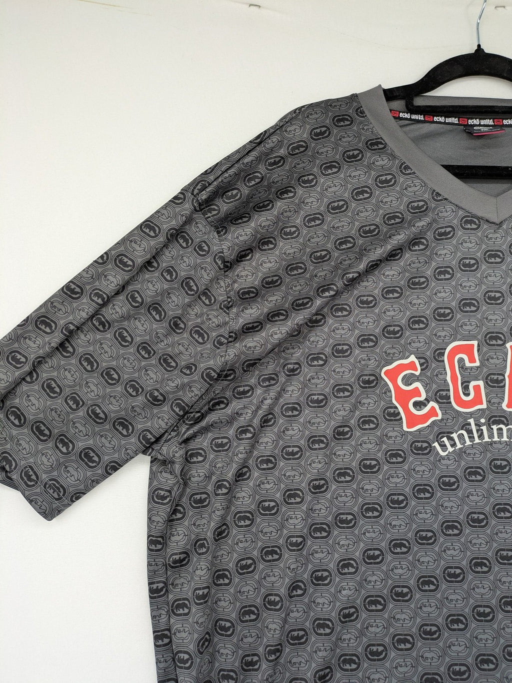 Ecko Unltd. grey soccer uniform V-neck with all-over logo print and embroidered FC patch.