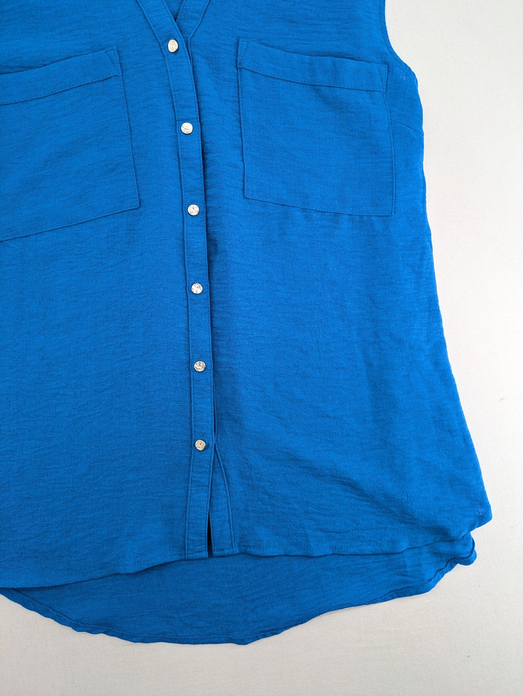Amisu blue sleeveless blouse with classic collar, button placket, and high-low hem.