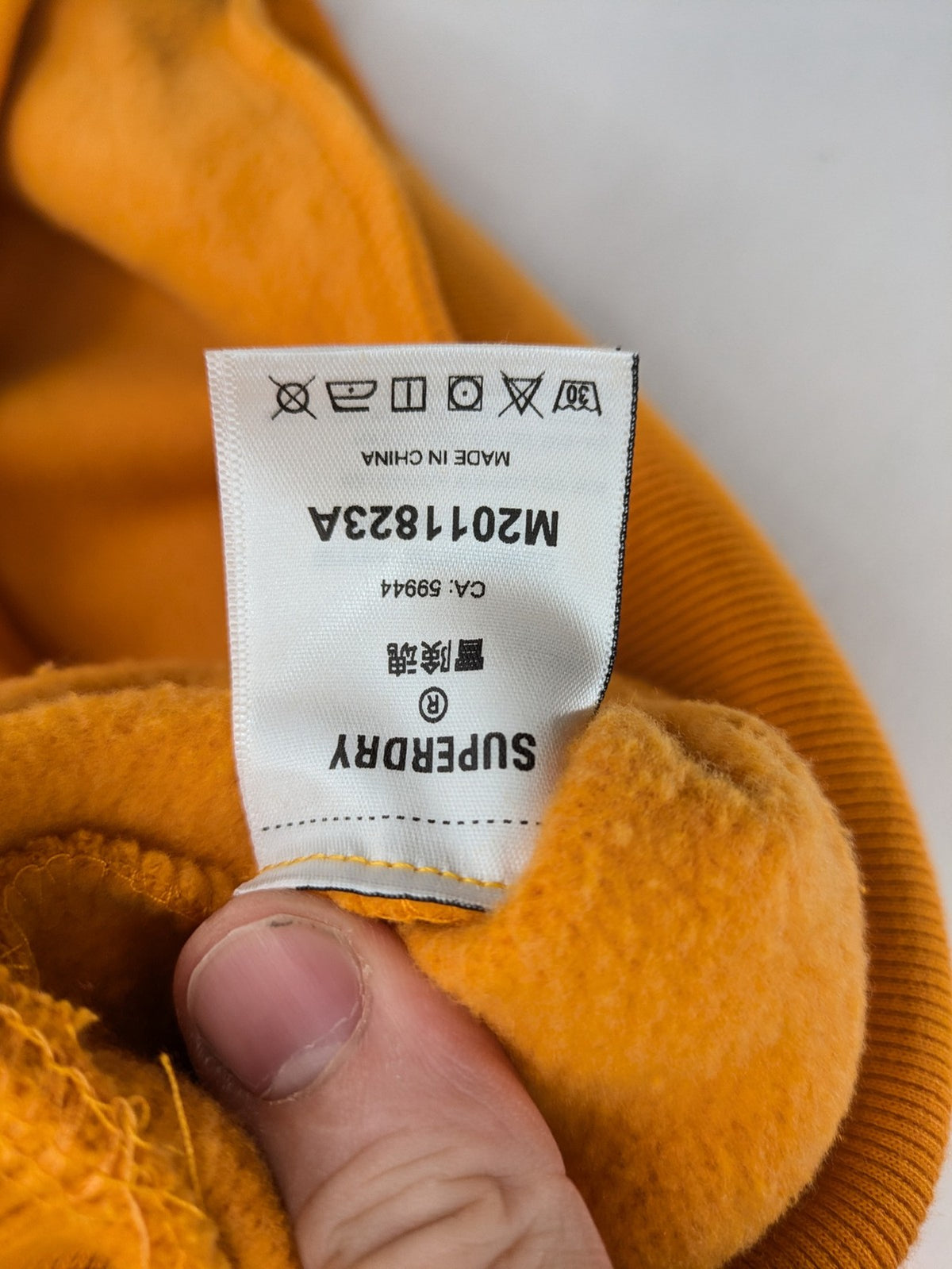 Superdry orange turtle neck jumper with textured logo patch and number 7 detail.