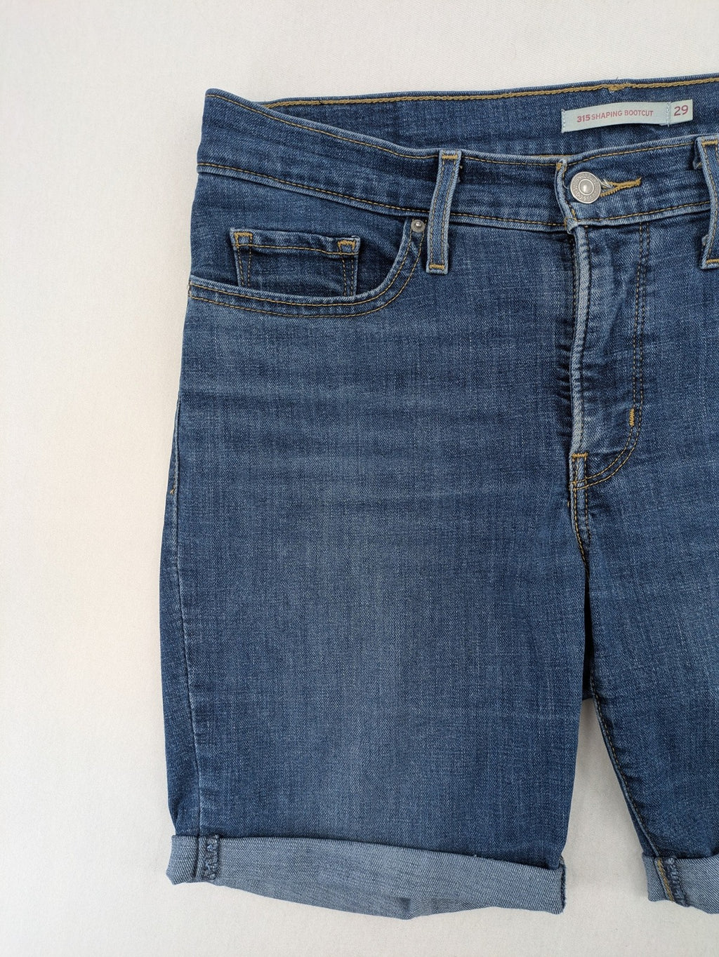 Levi's blue denim Bermuda shorts with rolled cuffs and classic 5-pocket design.