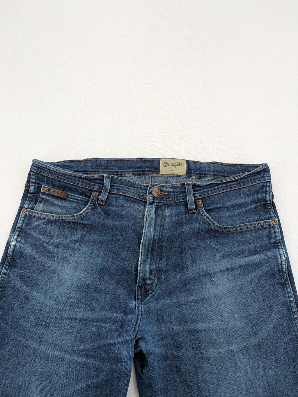 Wrangler straight jeans blue with iconic "W" stitching on back pockets.