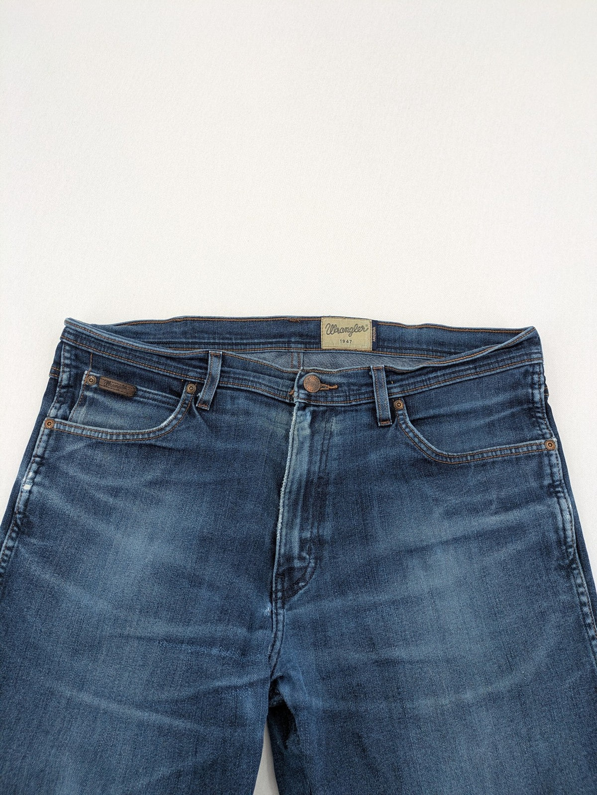 Wrangler straight jeans blue with iconic "W" stitching on back pockets.
