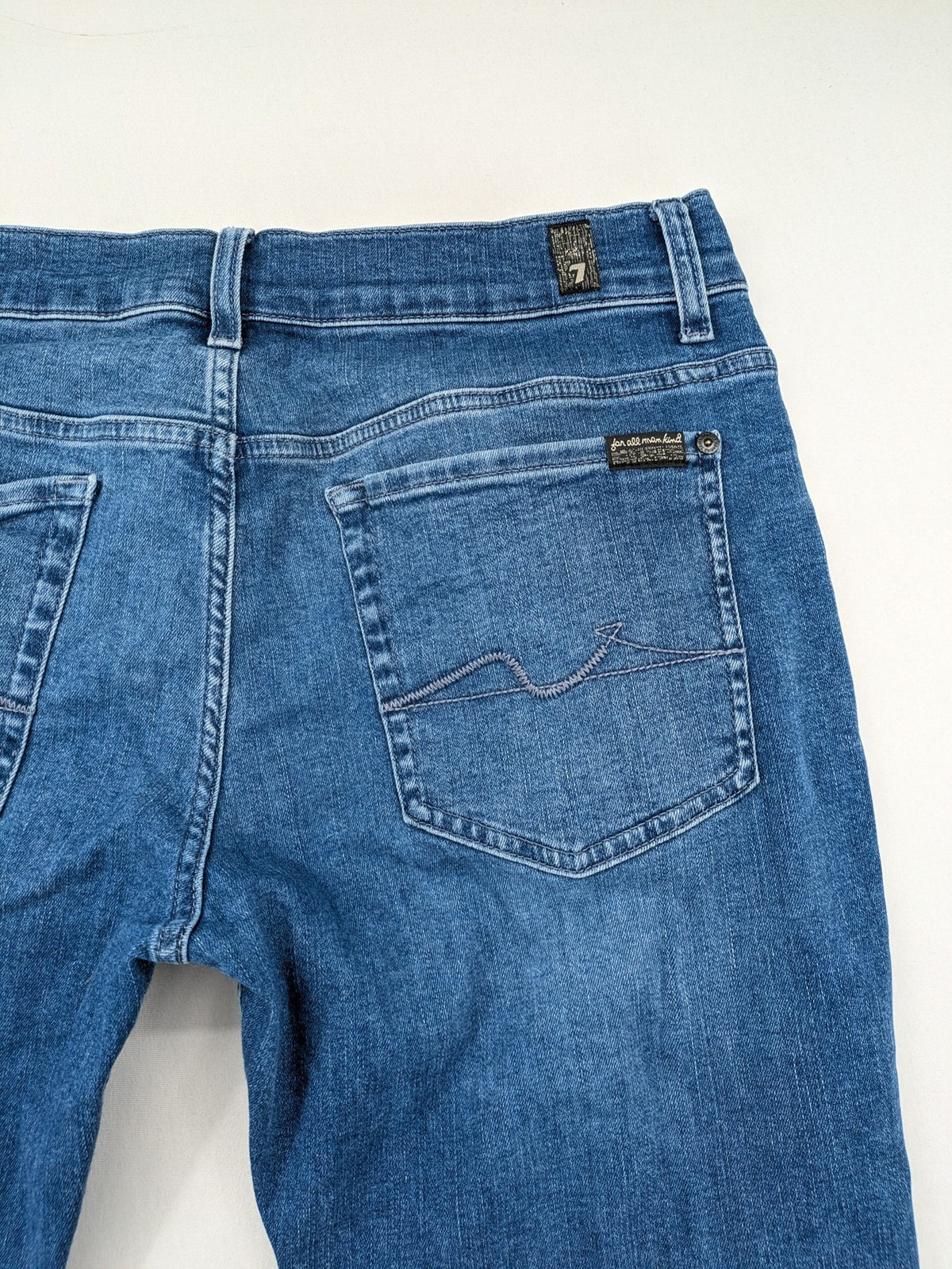7 For All Mankind blue straight jeans with 5-pocket design and logo on back pocket.
