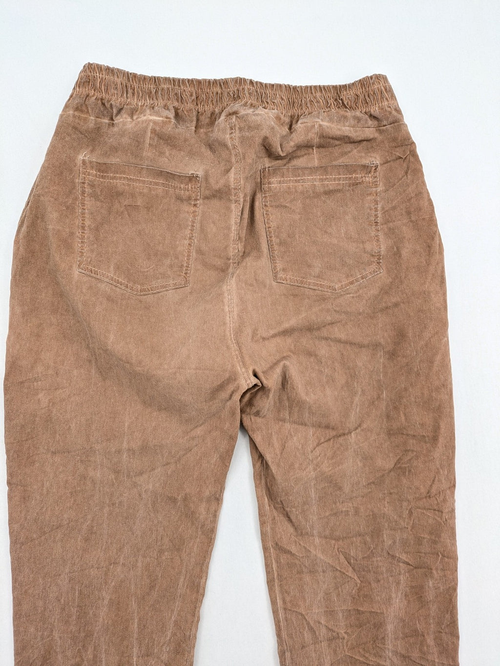 TREDY brown high-waist pants with decorative button placket and elastic waistband, soft knit texture.