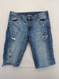 Denim blue distressed jeans shorts with frayed edges and a trendy used look.