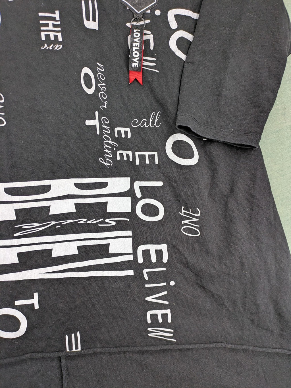 MEGI Collection black hoodie dress with graphic print and asymmetrical high-low hem.