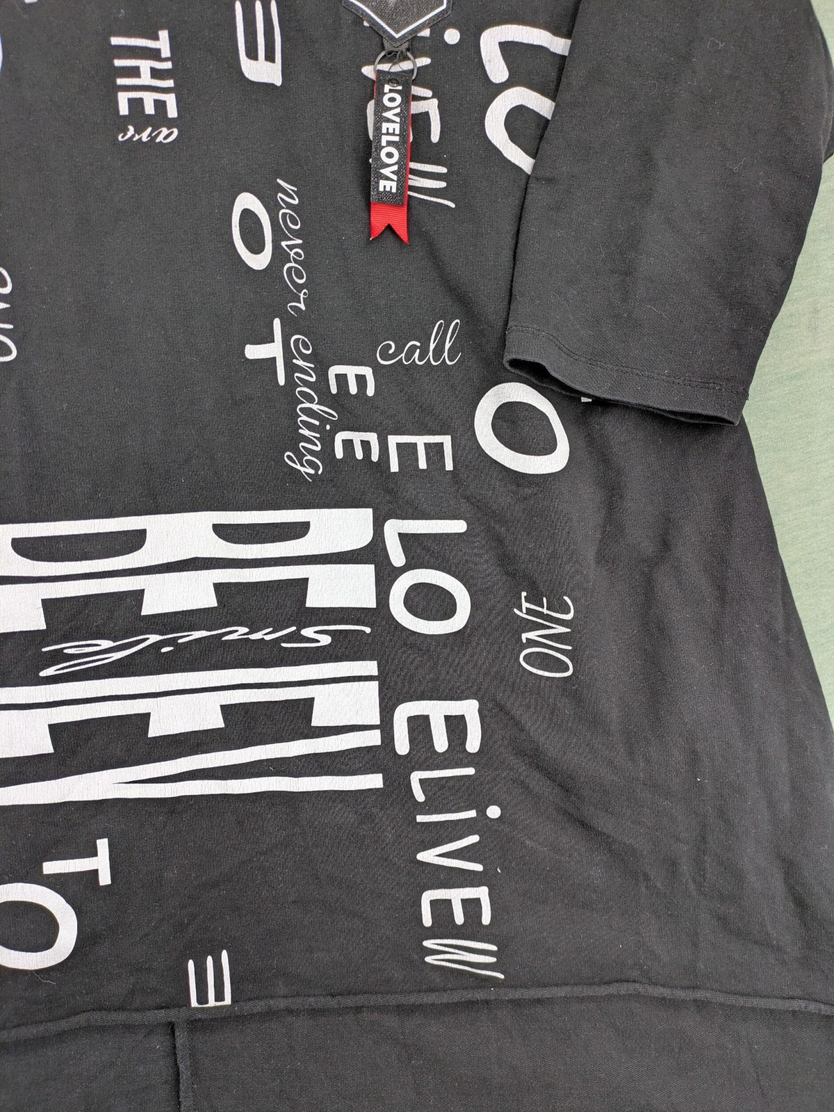 MEGI Collection black hoodie dress with graphic print and asymmetrical high-low hem.