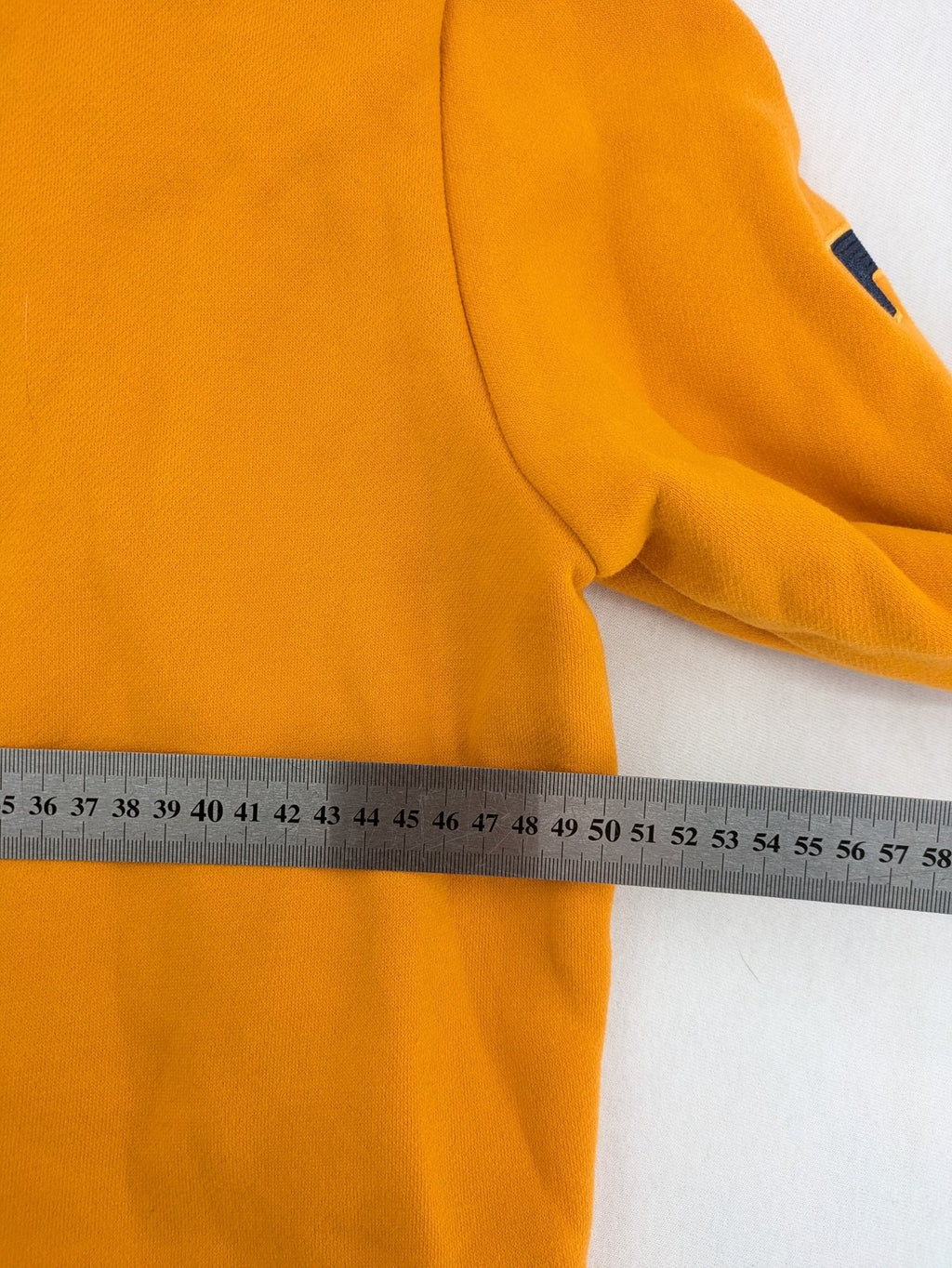 Superdry orange turtle neck jumper with textured logo patch and number 7 detail.