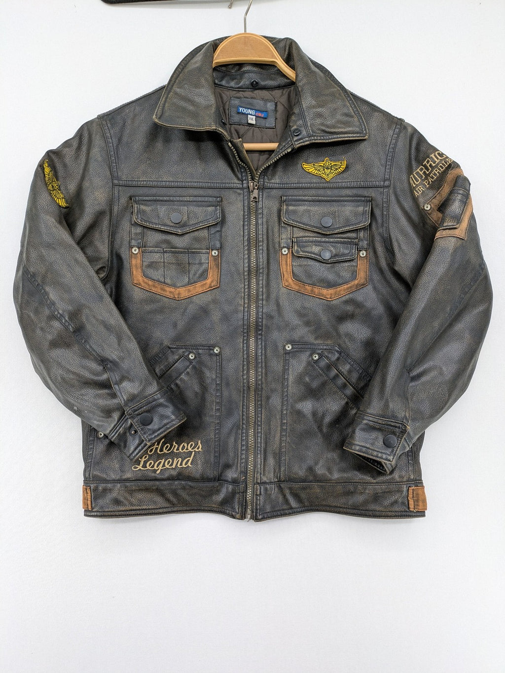 Junge brown bomber jacket with vintage patches and embroidered details in faux leather.