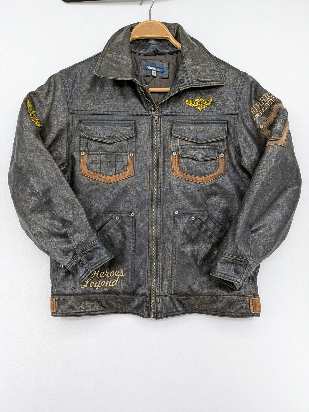 Junge brown bomber jacket with vintage patches and embroidered details in faux leather.
