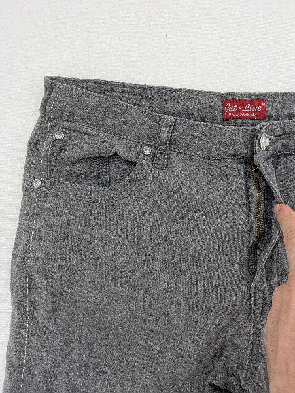 Jet Line grey straight jeans with embellished back pockets and frayed hem details.