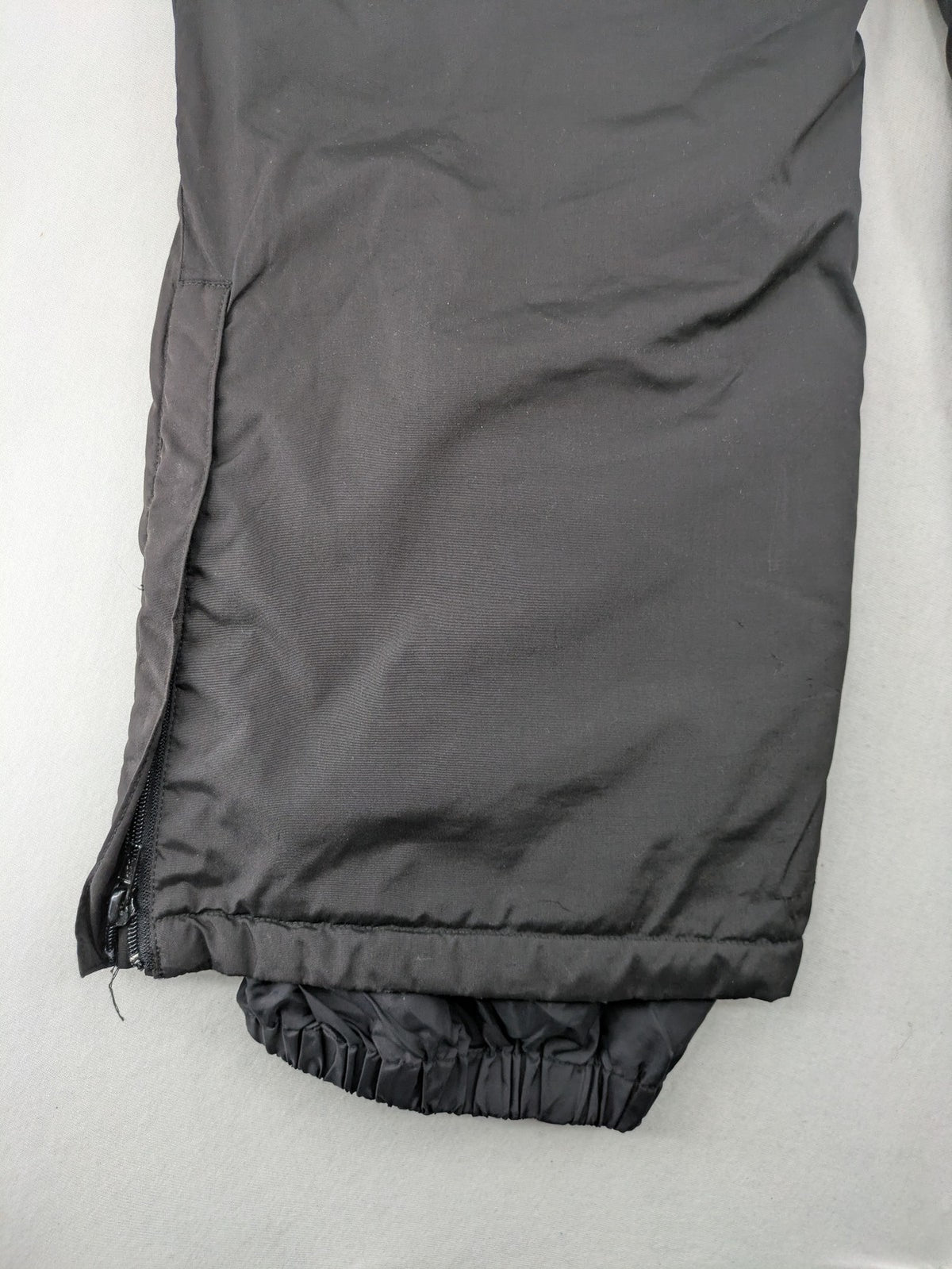 GEF black ski pants size 40, insulated, featuring zippered cuffs and snow gaiters.