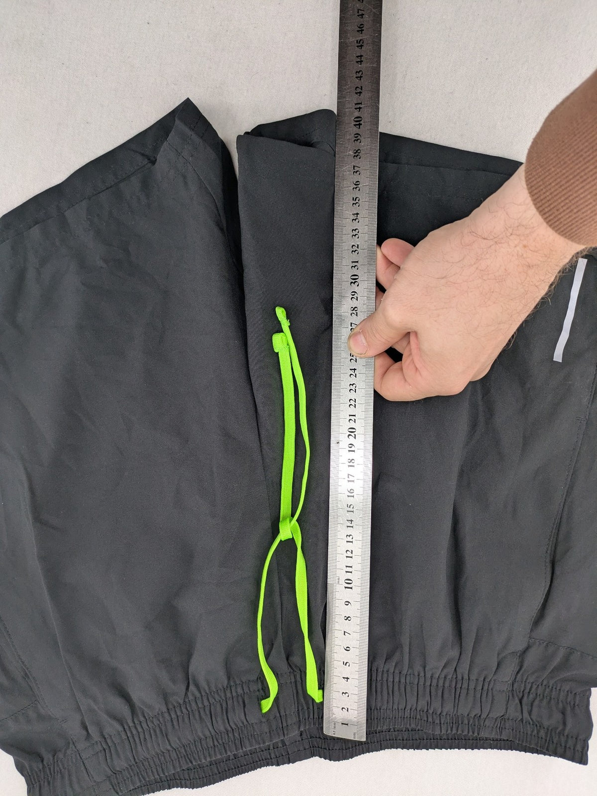 Crivit black running shorts with neon green accents, elastic waistband, and reflective details.