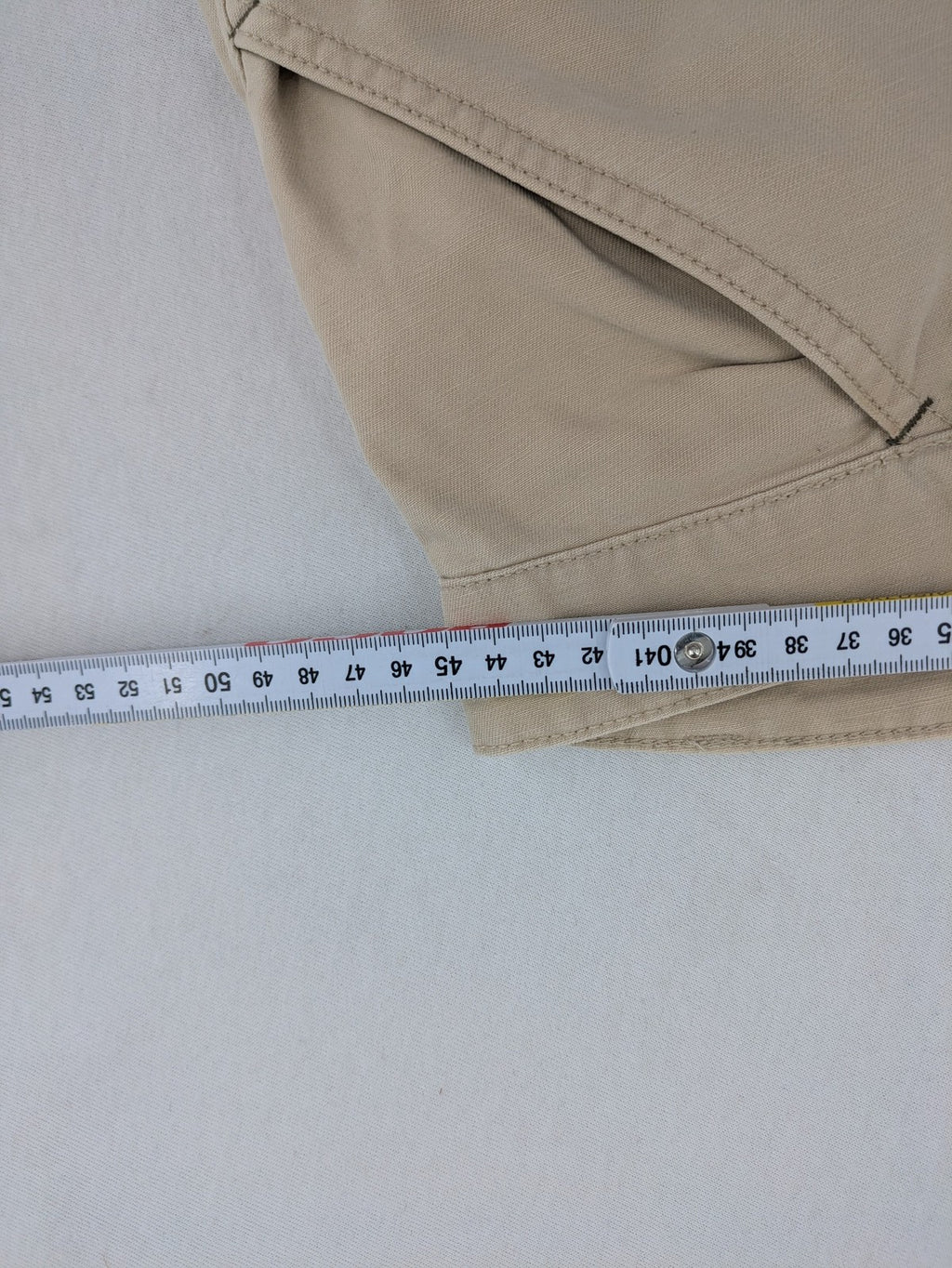 Cottonfield beige cargo pants with multiple pockets and button flaps.