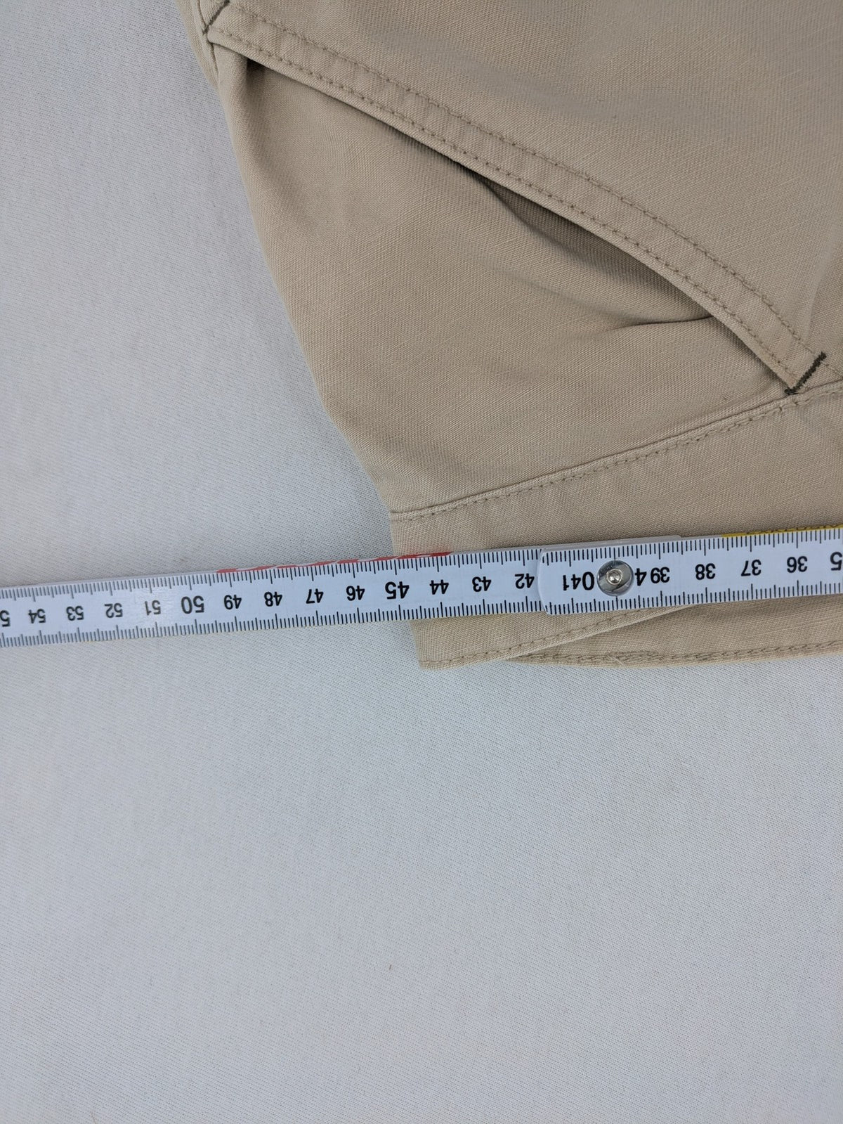 Cottonfield beige cargo pants with multiple pockets and button flaps.
