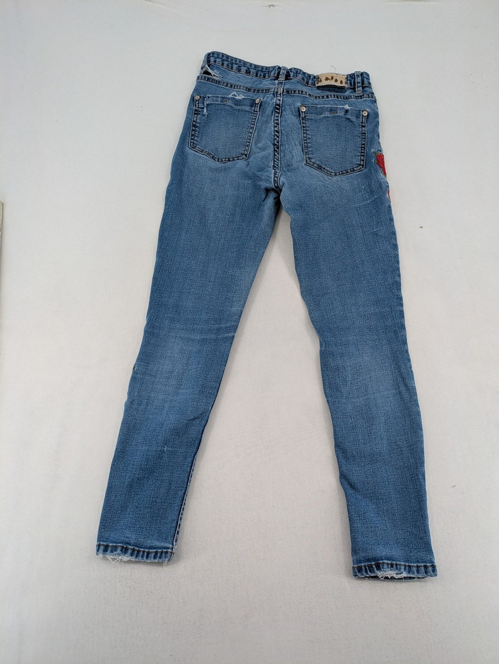 Jennyfer pink skinny jeans with distressed details and red rose embroidery on hips and knees.