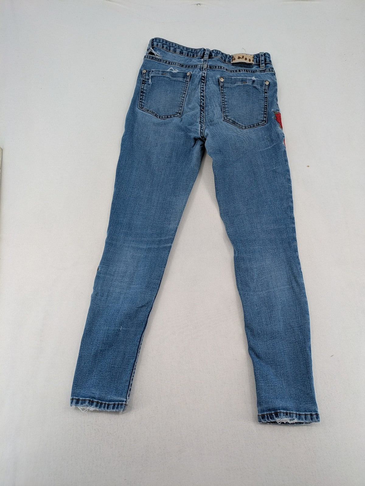 Jennyfer pink skinny jeans with distressed details and red rose embroidery on hips and knees.