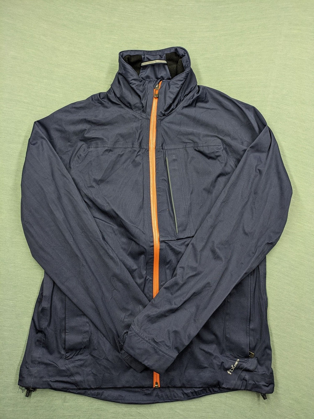 Cross Sportswear orange golf jacket with full zip, high collar, and contrast zipper details.