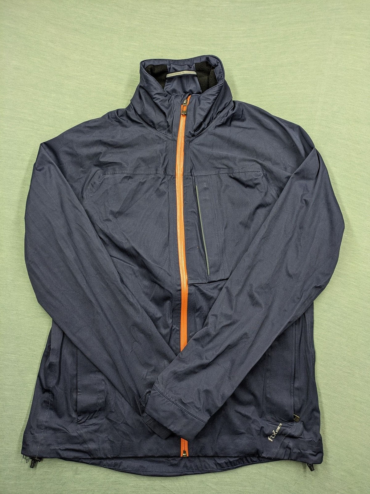 Cross Sportswear orange golf jacket with full zip, high collar, and contrast zipper details.