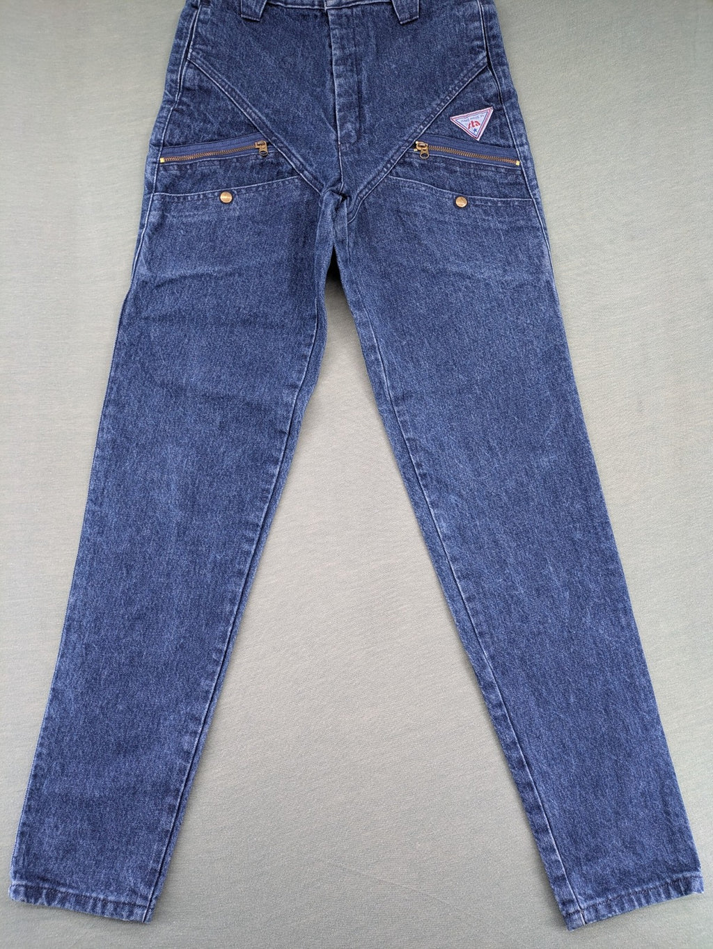 YKK blue high waist mom jeans with decorative front zipper pockets and vintage denim texture.