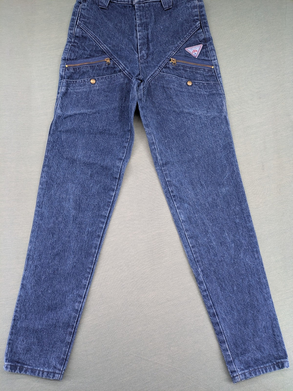 YKK blue high waist mom jeans with decorative front zipper pockets and vintage denim texture.