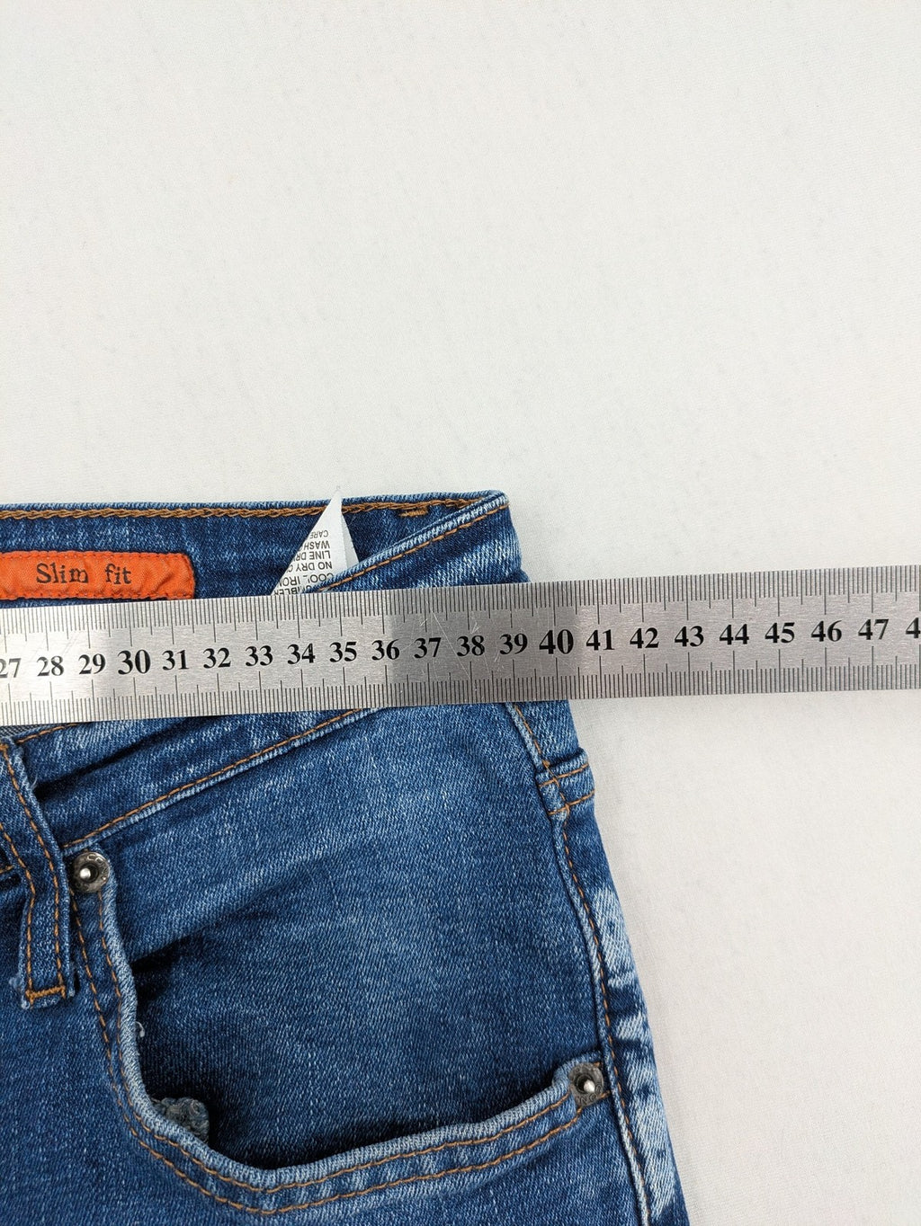 ICON 2 blue slim fit jeans distressed stretch denim with button fly and faded details.