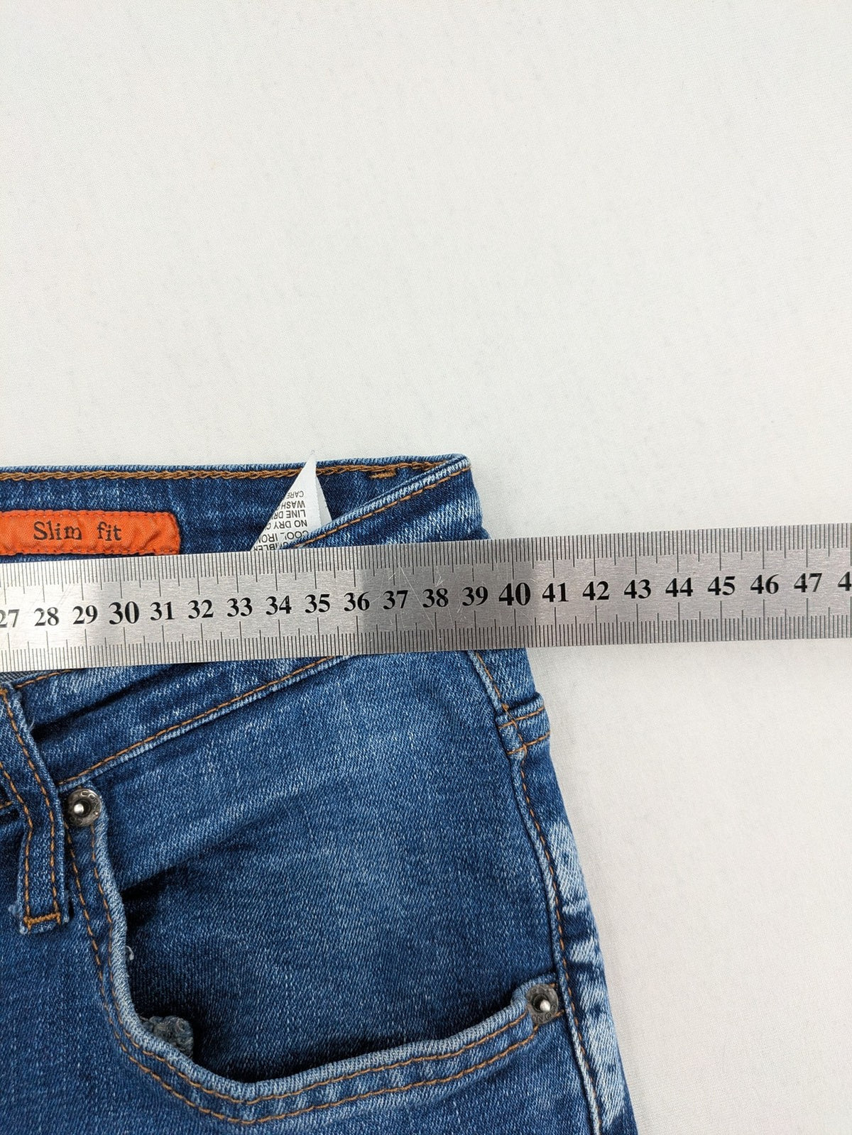 ICON 2 blue slim fit jeans distressed stretch denim with button fly and faded details.