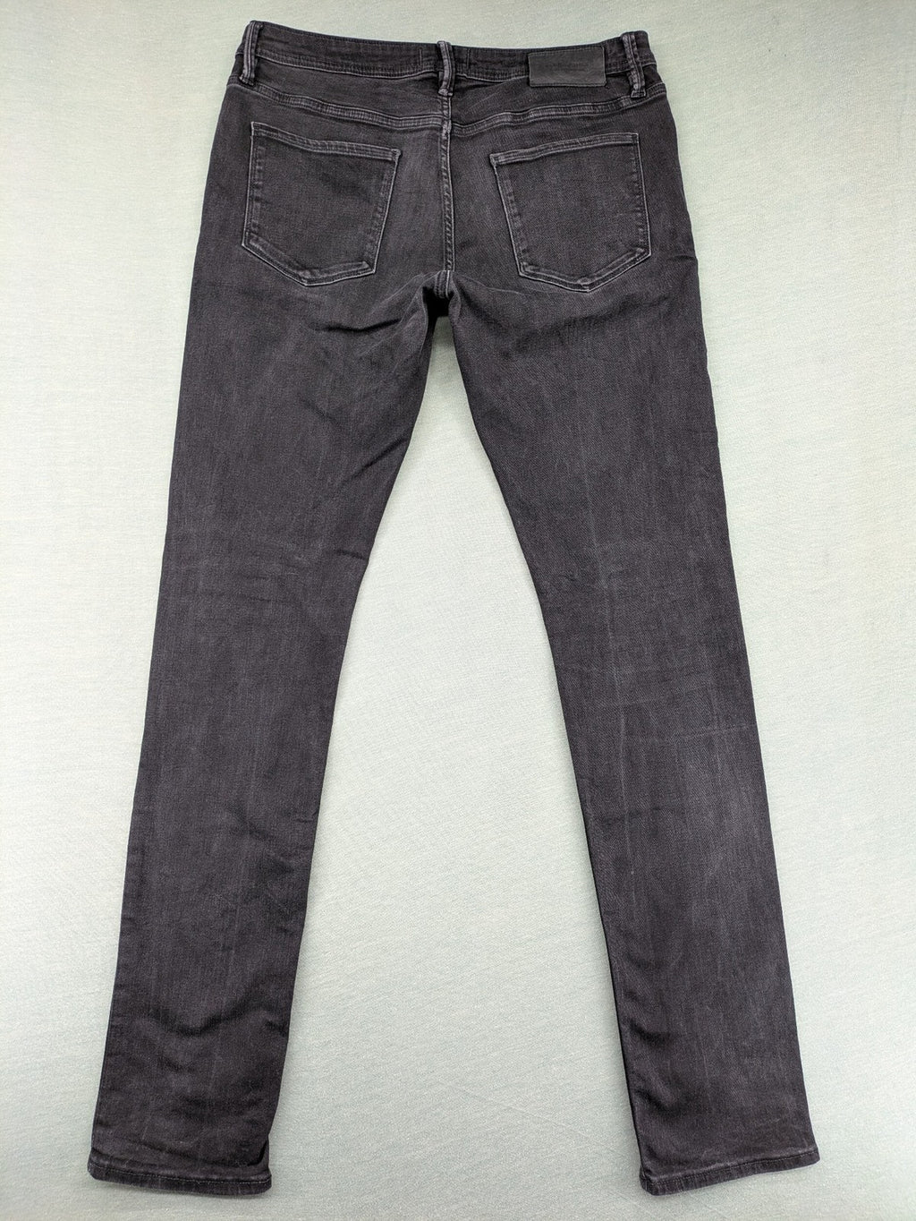 Jack & Jones black slim fit jeans faded wash stretch denim with logo detail.